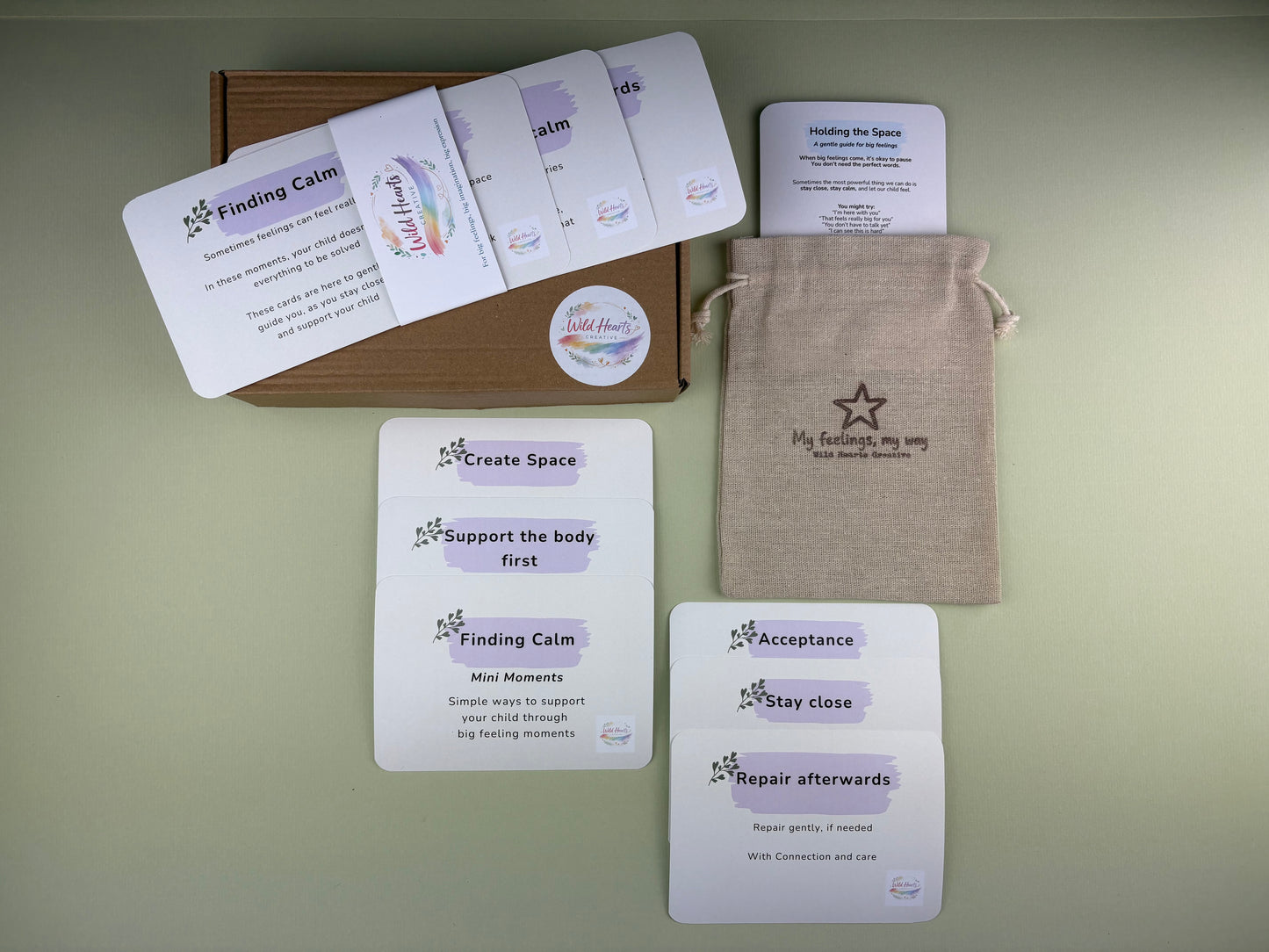 Flat lay of the Finding Calm Mini Moments support kit for adults, featuring calming prompt cards, reassurance cards, a drawstring pouch and Wild Hearts Creative packaging.