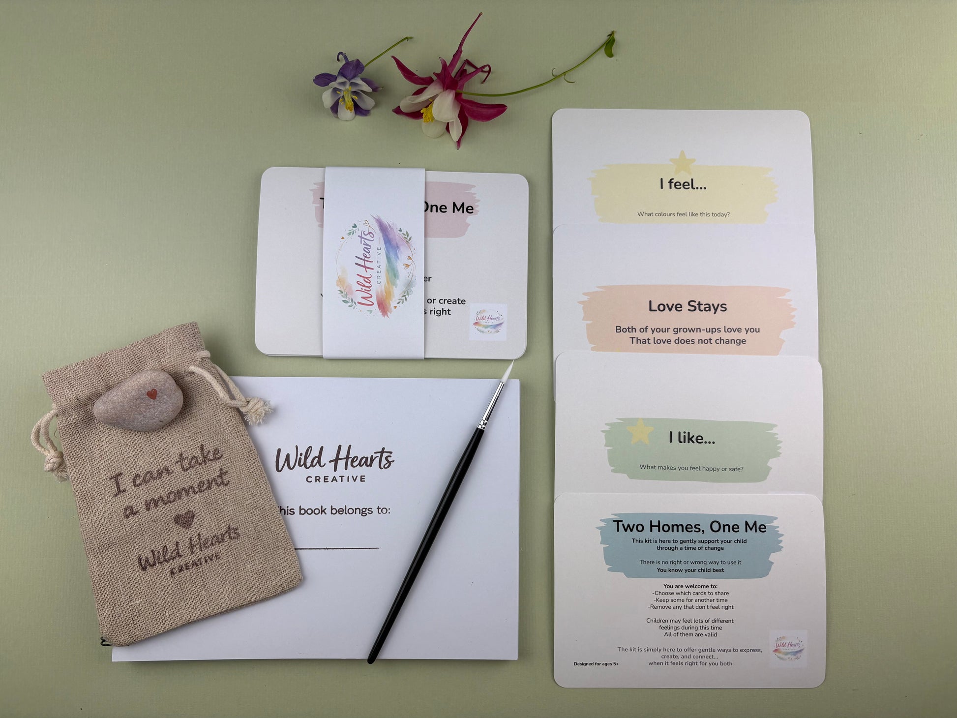 Flat lay of the Two Homes, One Me divorce and separation creative support kit for children, featuring prompt cards, comfort stones, creative resources and comfort items designed to support emotional wellbeing.