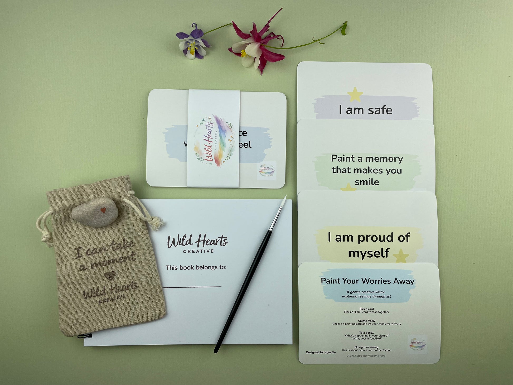 Flat lay of the Paint Your Worries Anxiety creative support kit for children, featuring prompt cards, creative resources and comfort items designed to support emotional wellbeing.