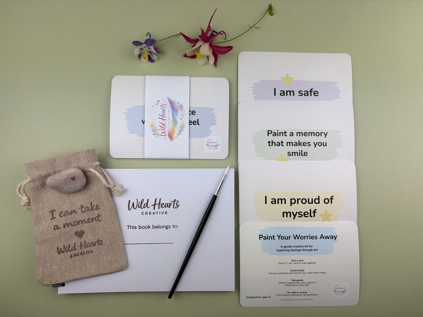 Flat lay of the Paint Your Worries Anxiety creative support kit for children, featuring prompt cards, creative resources and comfort items designed to support emotional wellbeing.