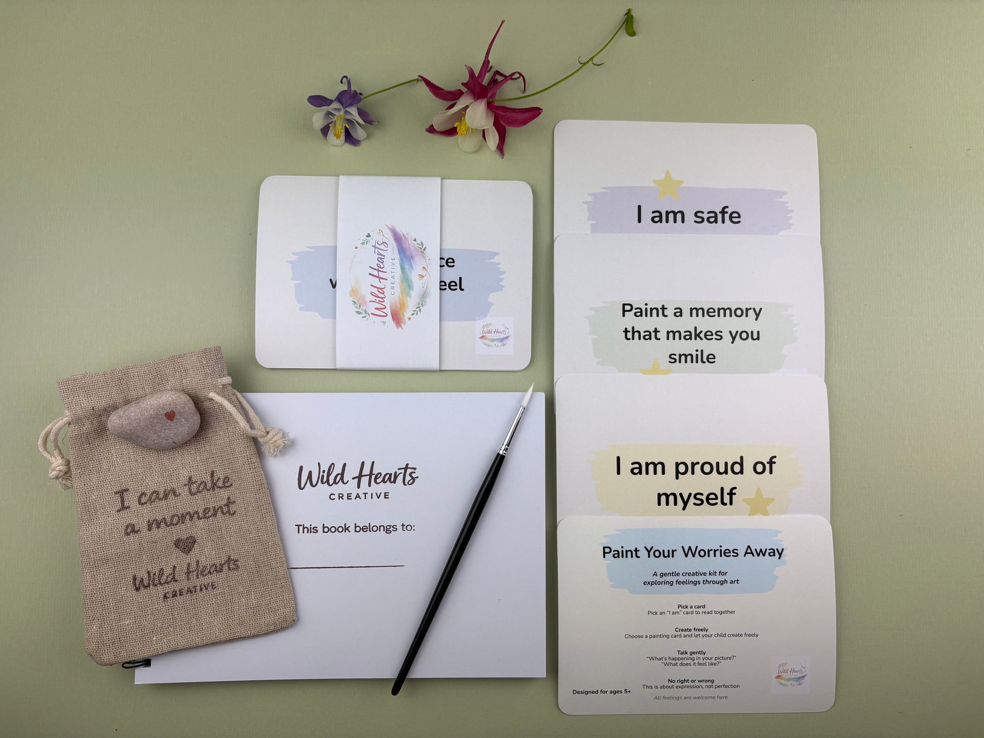 Flat lay of the Paint Your Worries Anxiety creative support kit for children, featuring prompt cards, creative resources and comfort items designed to support emotional wellbeing.