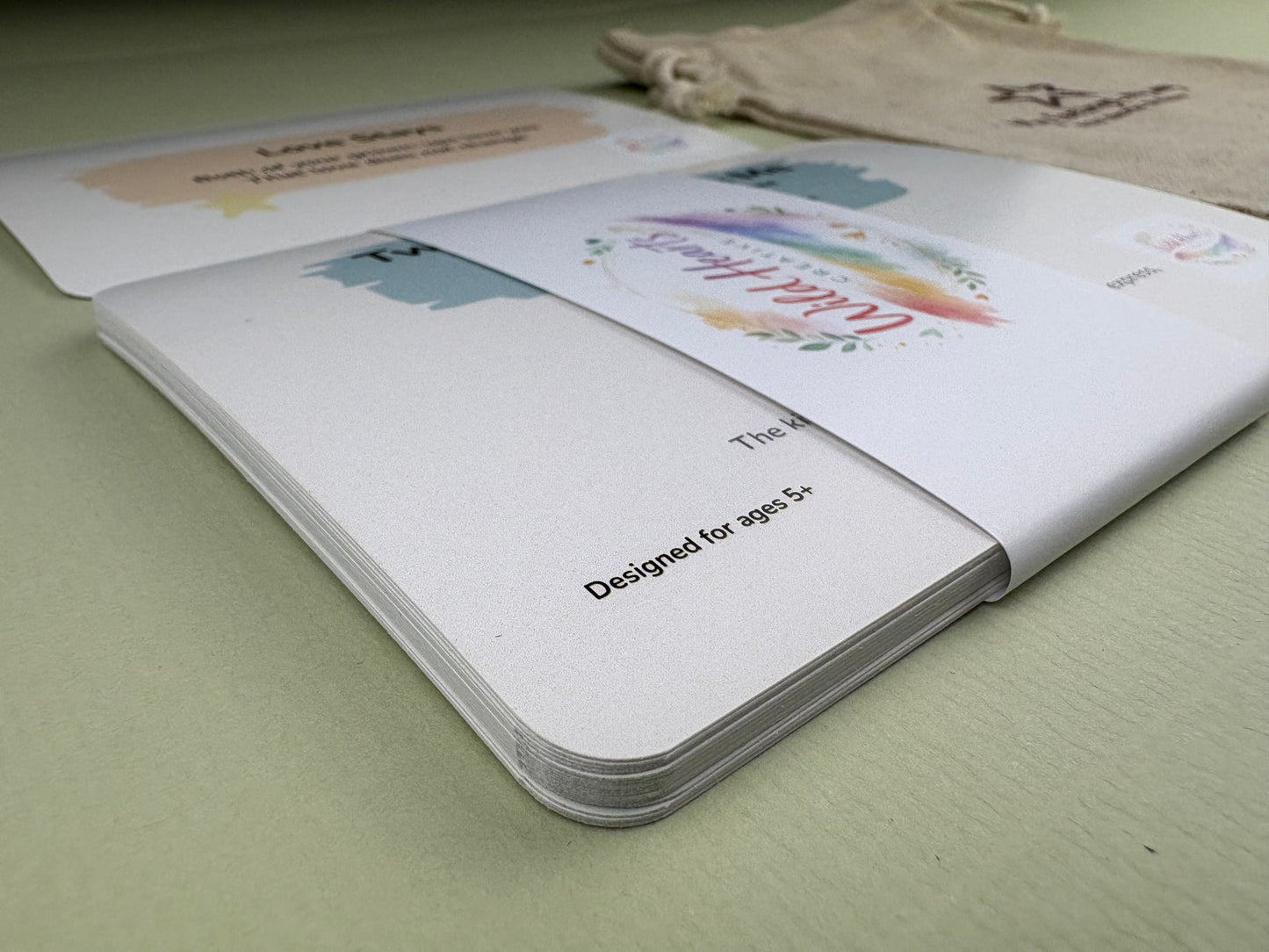 Close-up of a Wild Hearts Creative card collection secured with a branded belly band, showcasing high-quality rounded cards designed to support children’s emotional wellbeing through creative prompts and affirmations.