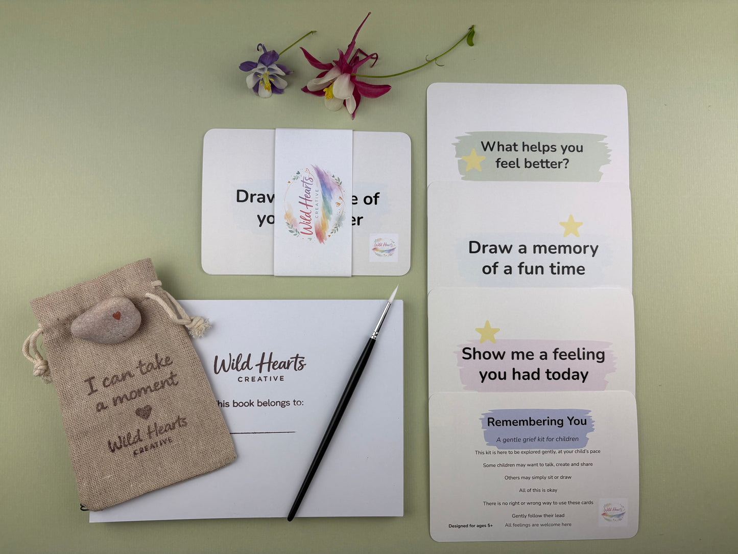 Flat lay of the Remembering You bereavement and grief creative support kit for children, featuring prompt cards, comfort stones, creative resources and comfort items designed to support emotional wellbeing.